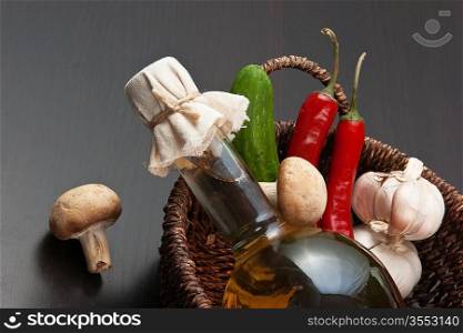 vegetables and a basket with a bottle of vinegar