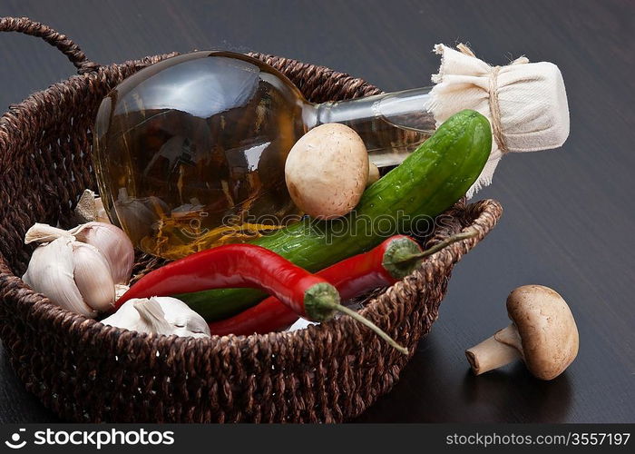 vegetables and a basket with a bottle of vinegar