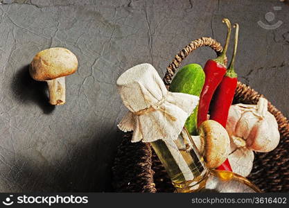 vegetables and a basket with a bottle of vinegar