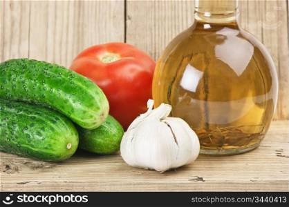 vegetables and a bottle of oil, still life on a wooden table