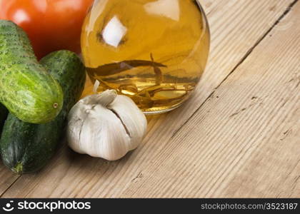 vegetables and a bottle of oil, still life on a wooden table