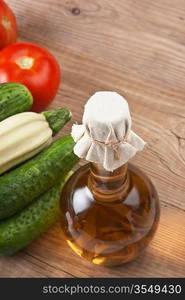 vegetables and a bottle of oil, still life on a wooden table