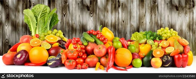 Vegetables and fruits on dark wooden wall background. Copy space