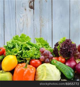 Vegetables and fruits on light blue wooden wall background. Healthy foods.