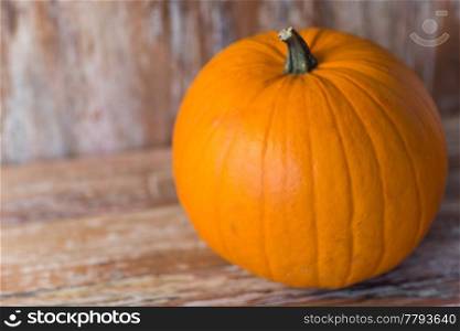 vegetables, harvest and thanksgiving concept - ripe pumpkin on wooden background. ripe pumpkin on wooden background