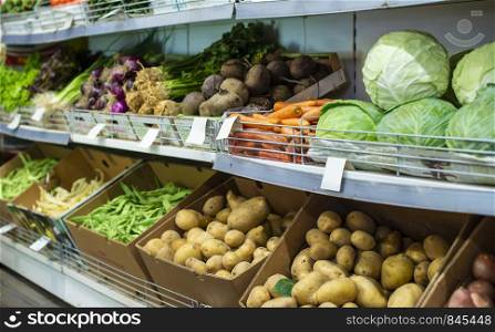 Vegetables on shelf in the market. Potatoes, celery, beetsand cabbage.