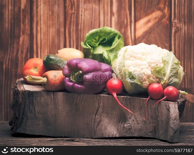 Vegetables still life. Vegetables on the wooden stump. Colorfull compostiton
