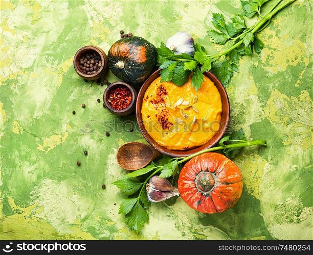 Vegetarian autumn pumpkin cream soup.Pumpkin soup and pumpkins.Flat lay with copy space. Pumpkin vegan soup
