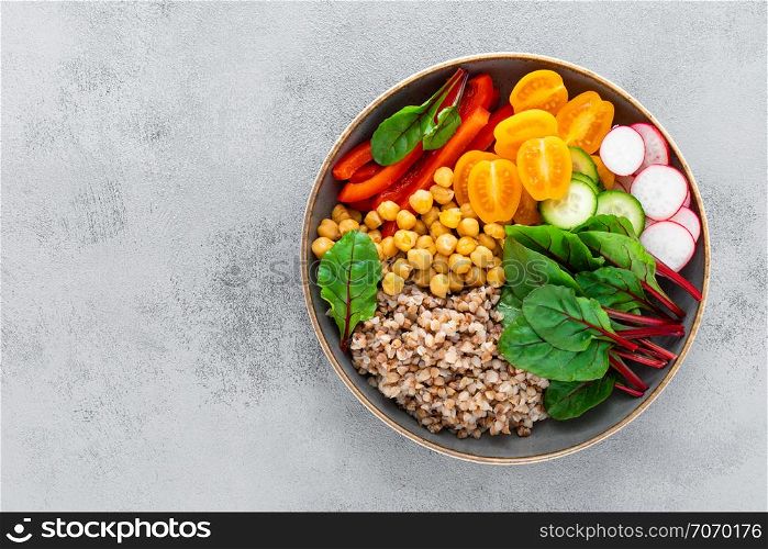 Vegetarian Buddha bowl with boiled buckwheat, chickpea and vegetables, top view