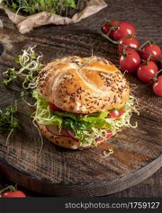 Vegetarian burger with broccoli, radish and fenugreek microgreens on a rustic background