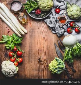 Vegetarian cooking concept with asparagus and Others organic harvest vegetables and ingredients on wooden rustic background, top view, frame