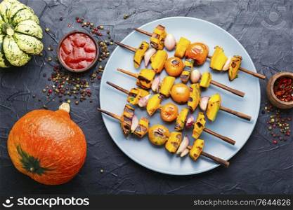 Vegetarian delicious pumpkin and tomato shashlik. Pumpkin fried on skewers.. Grilled pumpkin on a skewer