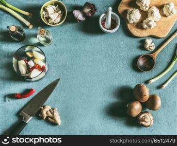 Vegetarian food background with knife , wooden spoon and various ingredients for tasty cooking and eating, top view