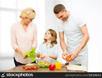 vegetarian food, culinary, happiness and people concept - happy family cooking vegetable salad for dinner over white room background