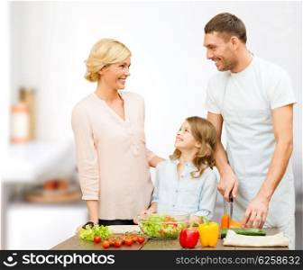 vegetarian food, culinary, happiness and people concept - happy family cooking vegetable salad for dinner and talking over home kitchen background
