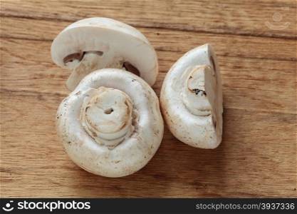Vegetarian food. Fresh white mushrooms champigonons on wooden kitchen table.