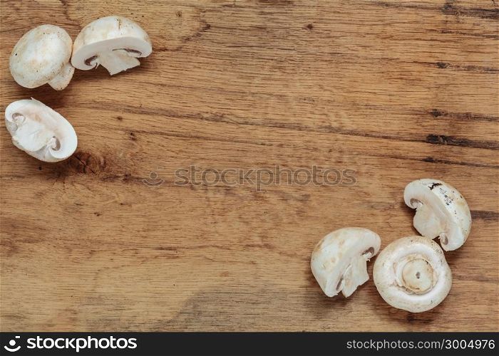 Vegetarian food. Fresh white mushrooms champigonons on wooden kitchen table as background.