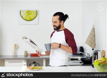 vegetarian food, healthy eating, people and diet concept - man having vegetable sandwiches with coffee for breakfast and reading newspaper at home kitchen. man reading newspaper and eating at home kitchen