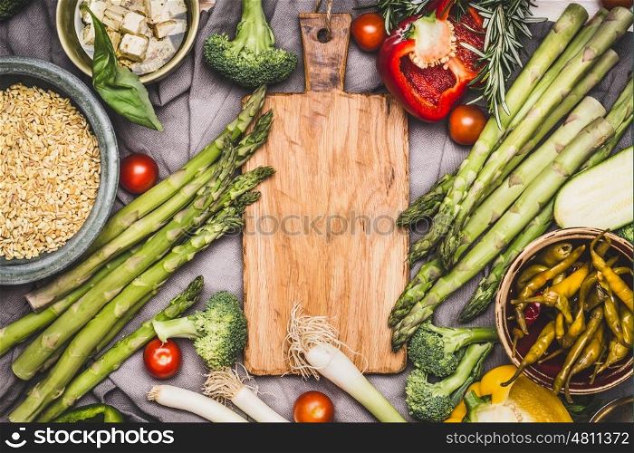 Vegetarian ingredients for pearl barley porridge or salad around wooden cutting board, top view. Healthy clean food or diet nutrition concept