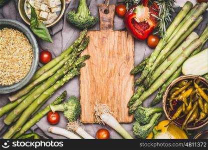 Vegetarian ingredients for pearl barley porridge or salad around wooden cutting board, top view. Healthy clean food or diet nutrition concept