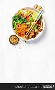 Vegetarian noodles with tofu, broccoli, mushrooms, carrot, bok choy on white stone table. Top view, flat lay, copyspace. Asian Tofu Soba Noodle Bowl