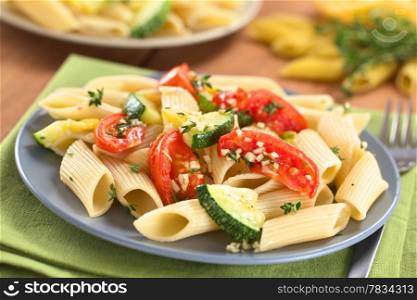 Vegetarian penne pasta dish with baked zucchini and tomato spiced with thyme and garlic (Selective Focus, Focus one third into the dish). Pasta with Zucchini and Tomato