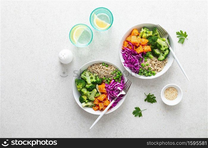 Vegetarian quinoa and broccoli lunch Buddha bowl with baked butternut squash or pumpkin, green peas and red cabbage, top down view