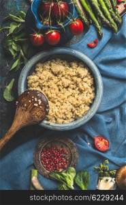 Vegetarian Quinoa dish with organic vegetables ingredients on dark blue background, top view. Superfood , healthy eating or vegetarian food concept.