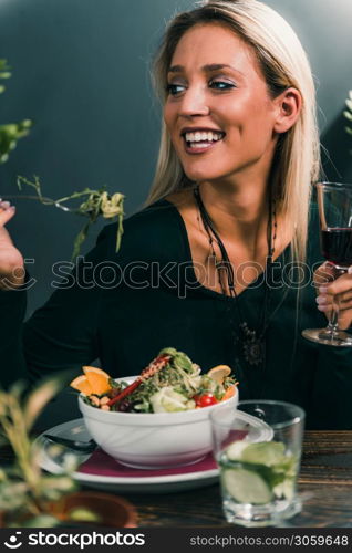 Vegetarian Restaurant. Cheerful Female Friends Enjoying Fresh Salad in Restaurant and Having Fun.