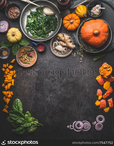 Vegetarian seasonal food background with ingredients for herbs and winter cooking: pumpkin,spinach, ginger, onion. Top view. Frame. Copy space