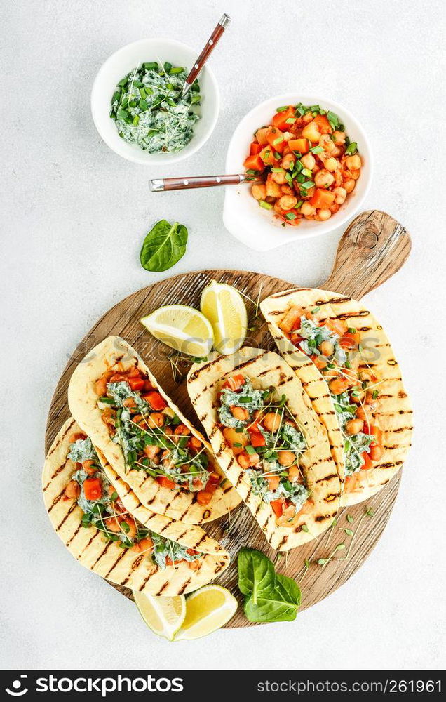 vegetarian snack of tacos with chickpea curry and sour cream sauce with