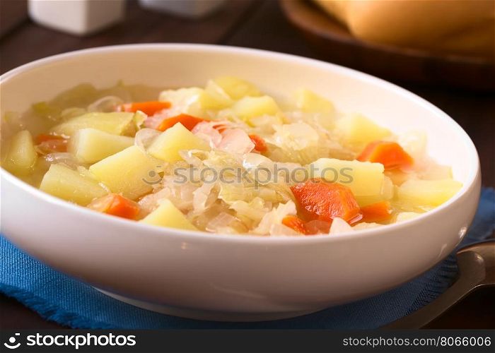 Vegetarian soup or stew made of sauerkraut, carrot and potato, photographed with natural light (Selective Focus, Focus one third into the dish)