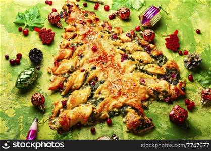 Vegetarian spinach pie for Christmas. Christmas cake and Christmas tree decorations.. Christmas cake with spinach and cheese.