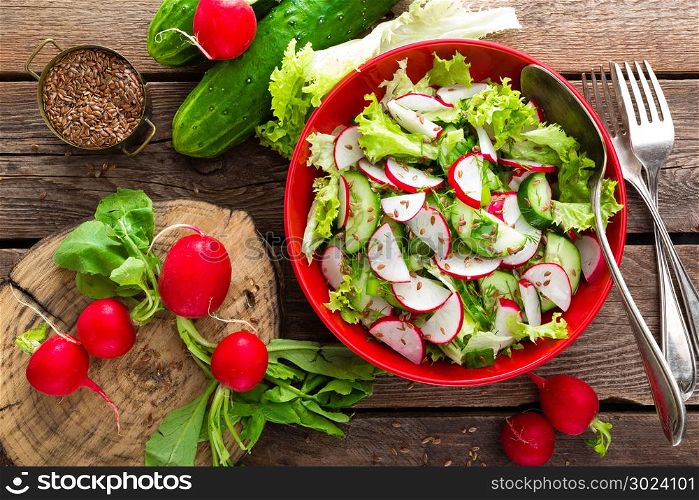 Vegetarian vegetable salad of radish, cucumbers, lettuce salad and flax seeds. Healthy vegan food. Top view