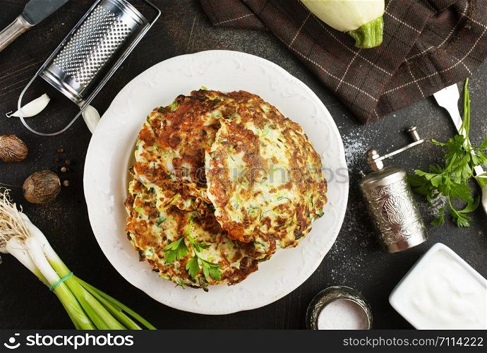Vegetarian zucchini pancakes stack with sour cream. Vegetable pancakes