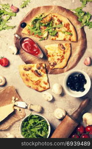 Veggie Pizza with ingredients on old stone background. Pizza with cheese mushrooms and ruccola. Rustic italian pizza