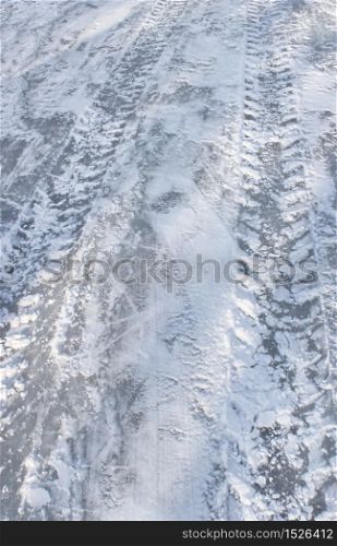 Vehicle tyre tracks on slippery icy winter road. Slippery ice road
