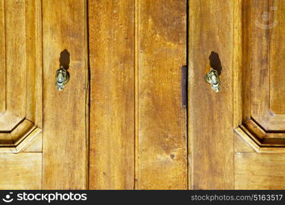 venegono abstract rusty brass brown knocker in a door curch closed wood lombardy italy varese