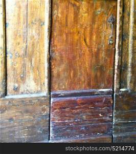 venegono abstract rusty brass brown knocker in a door curch closed wood lombardy italy varese