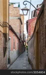 Venetian buildings represented onnarrow street in Italy. Narrow road in Venice, Italy.. Venetian buildings in Italy