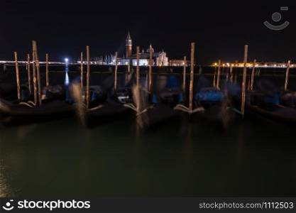 Venice canal with gondolas at night. Italy.