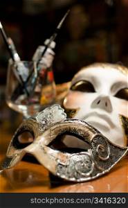 Venice carnival mask. Still-life with two venice carnival masks, paints and brushes