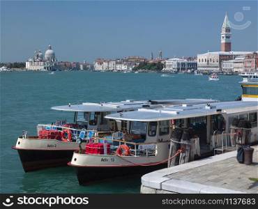 Venice. Italy. 08.29.04. Two vaporetto (Venetian public waterbuses) moored at the Arsenale with views towards the Doges Palace and St Marks Square in the city of Venice, Italy.