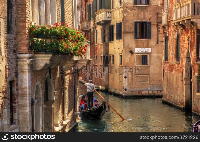 Venice, Italy. A romantic gondola floats on a narrow canal among old Venetian architecture