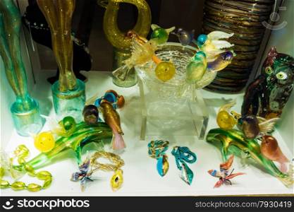 VENICE, ITALY - JUNE 1, 2014: Murano glass on display in window shop in market, Venice. Murano glass is a famous product of the Venetian island of Murano, traditional manufacturing centre.Glass-work in Murano island