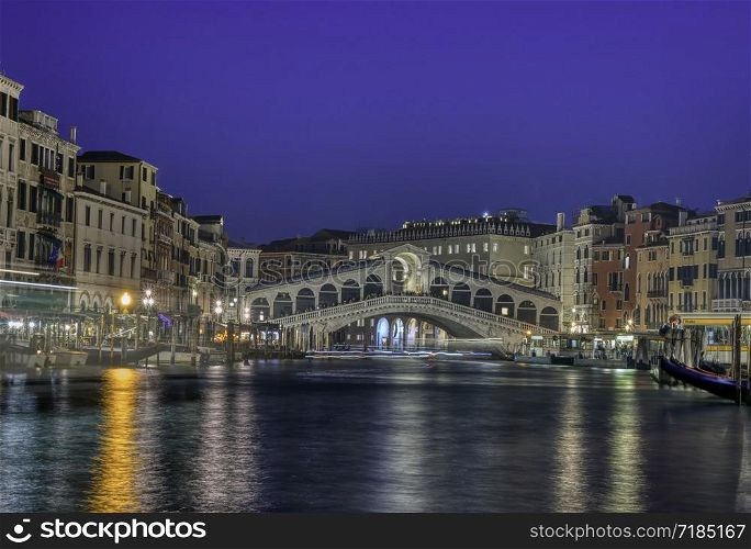 Venice, Italy - October 12, 2019: View of the Rialto Bridge and Grand Canal in a blue hour at sunset. Venice. Italy.