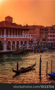 Venice, Italy - October 13, 2019: Beautiful view of traditional Gondola on famous Grand Canal in golden evening light at sunset in Venice, Italy.