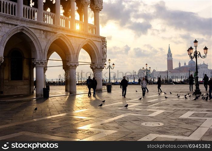 VENICE, ITALY - OCTOBER 26, 2017: Tourists walking at sunny Piazza San Marco in Venice