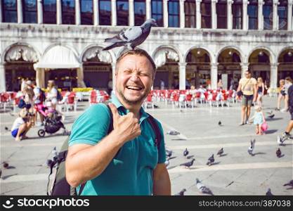 VENICE, ITALY - SEPTEMBER 28, 2016: view at the happy smiling man with dove on the Piazza San Marco, venice