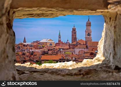 Venice towers and rooftops view through stone window, tourist destination in Veneto region of Italy